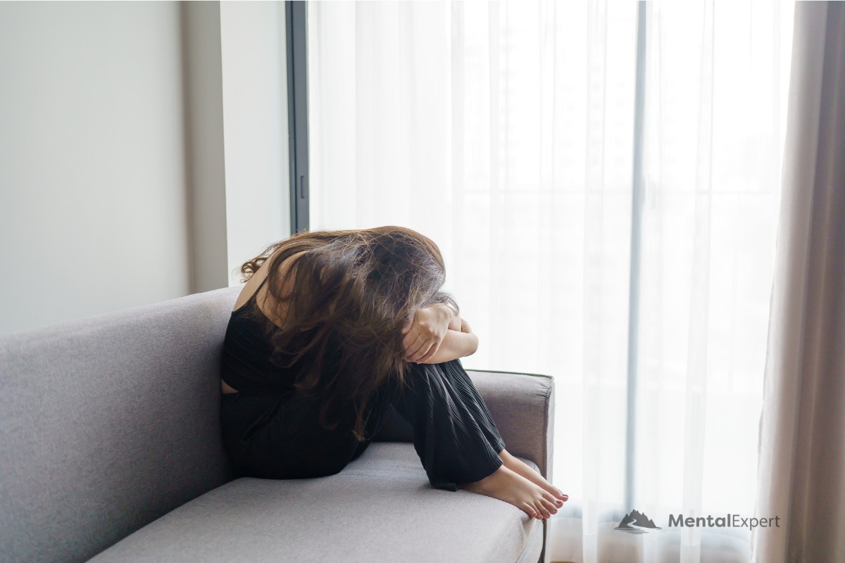Leczenie depresji bez leków - załamana kobieta siedząca na sofie