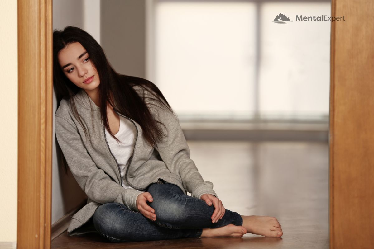 Objawy depresji - kobieta oparta o framugę drzwi